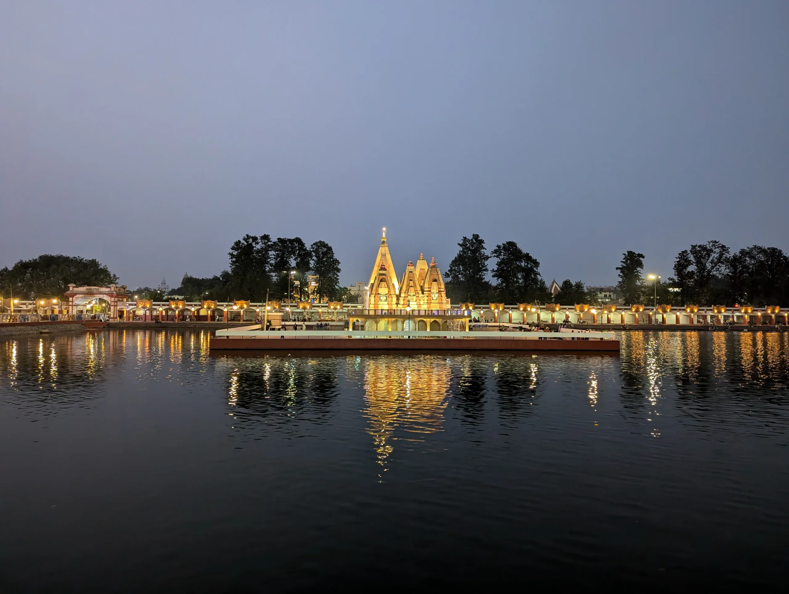 Sarveshwar Mahadev Temple glowing at night on Brahma Sarovar in Kurukshetra with lights reflecting across the water